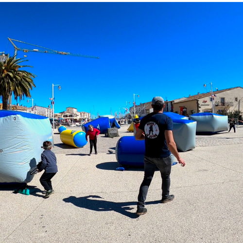 Animations pour fêtes à Marseillan : enfants et adultes participent à un Laser Game en plein air avec obstacles gonflables lors de la fête du printemps.